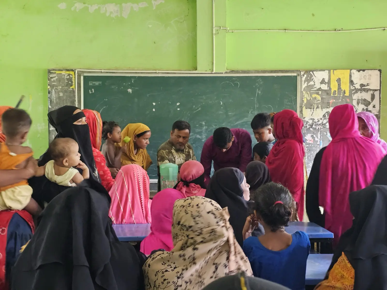Families fill the clinic room in Baishmouja on a Friday morning, waiting for consultations