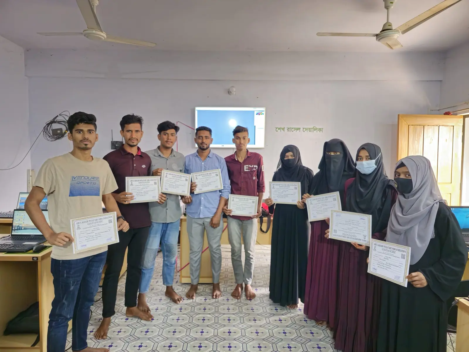 A graduating batch of students holds their certificates at the Abul Khair Computer Training Center