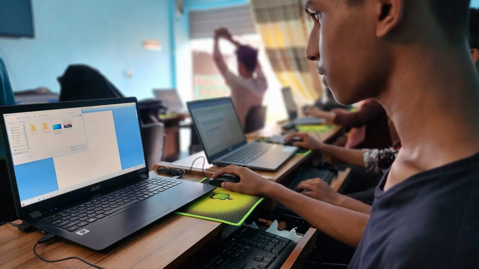 A student follows a lesson on a laptop at the Abul Khair Computer Training Center