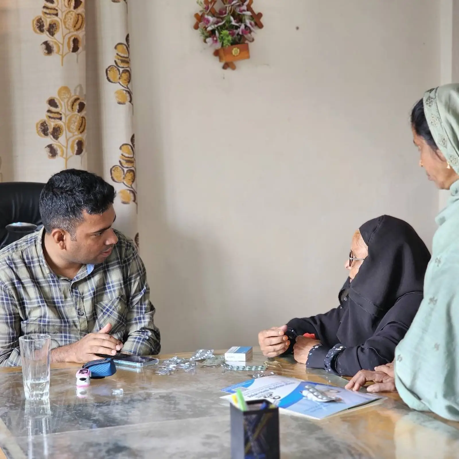 A doctor and a clinic assistant consult a patient during a February 2025 clinic day