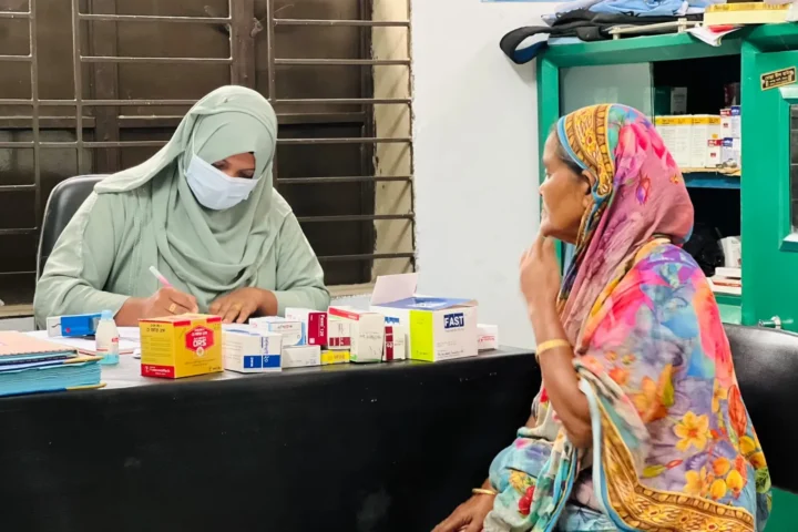 A clinic assistant hands medicine to a woman at the free medical camp on 1 May 2026