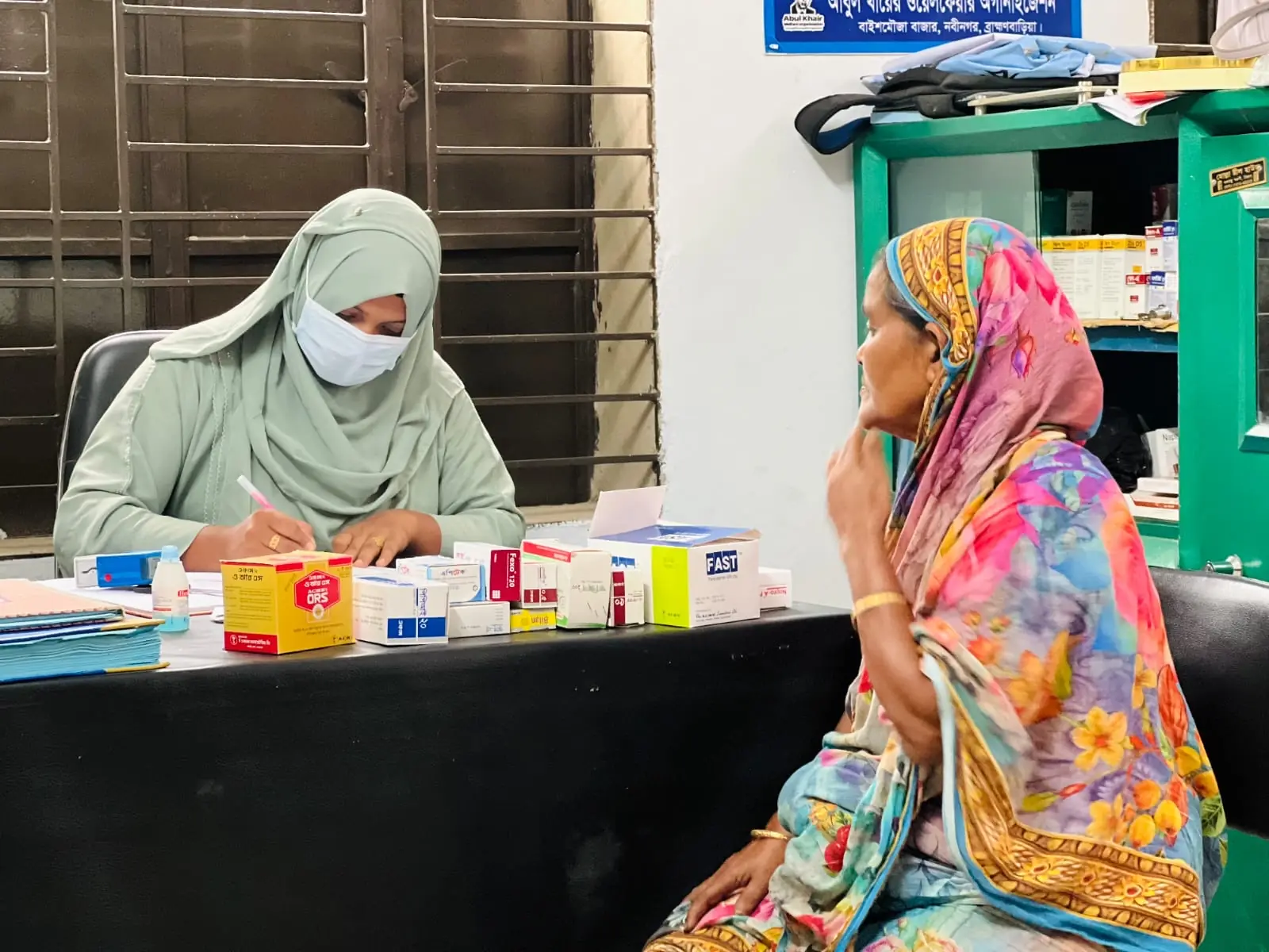 A clinic assistant hands medicine to a woman at the free medical camp on 1 May 2026
