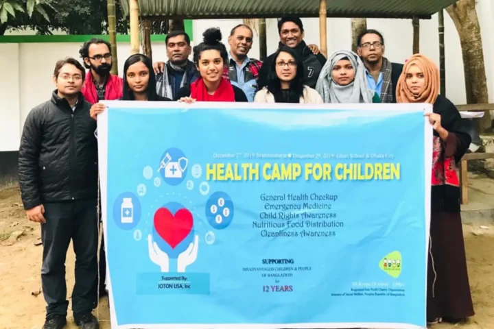 Volunteers hold the Health Camp for Children banner at the start of a camp in 2020