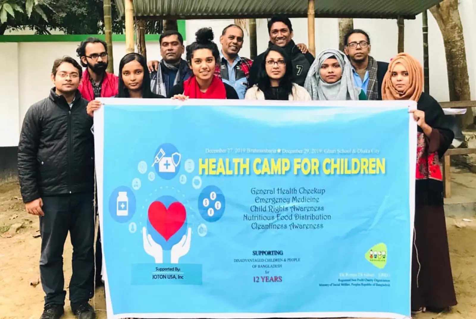 Volunteers hold the Health Camp for Children banner at the start of a camp in 2020