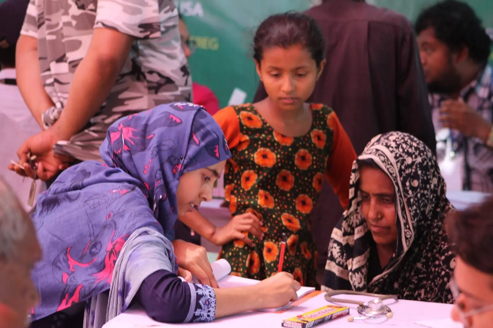 Volunteers register women and children at a village health camp in 2019