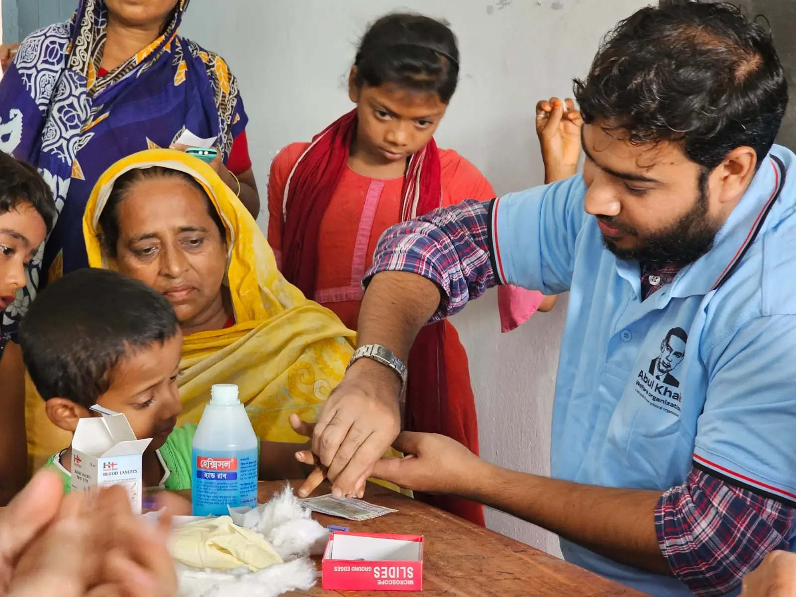 A health worker treats a young child on his mother's lap during a mobile health campaign