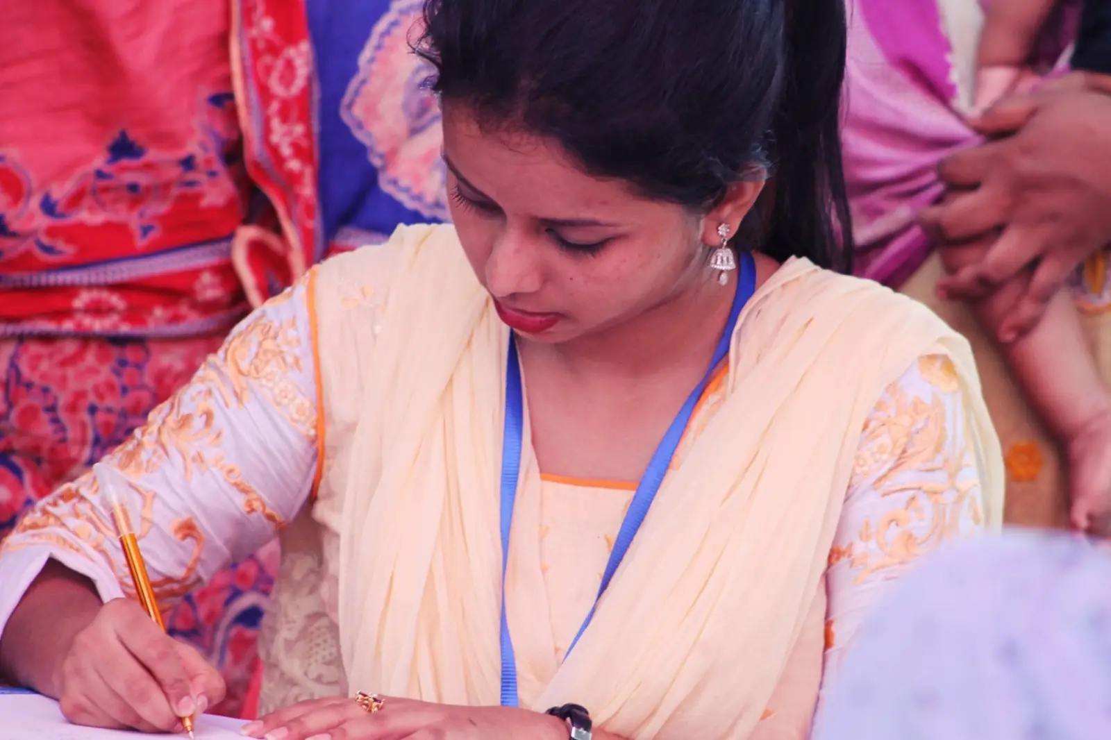 A nurse writes down a patient's details at a village health camp in 2019