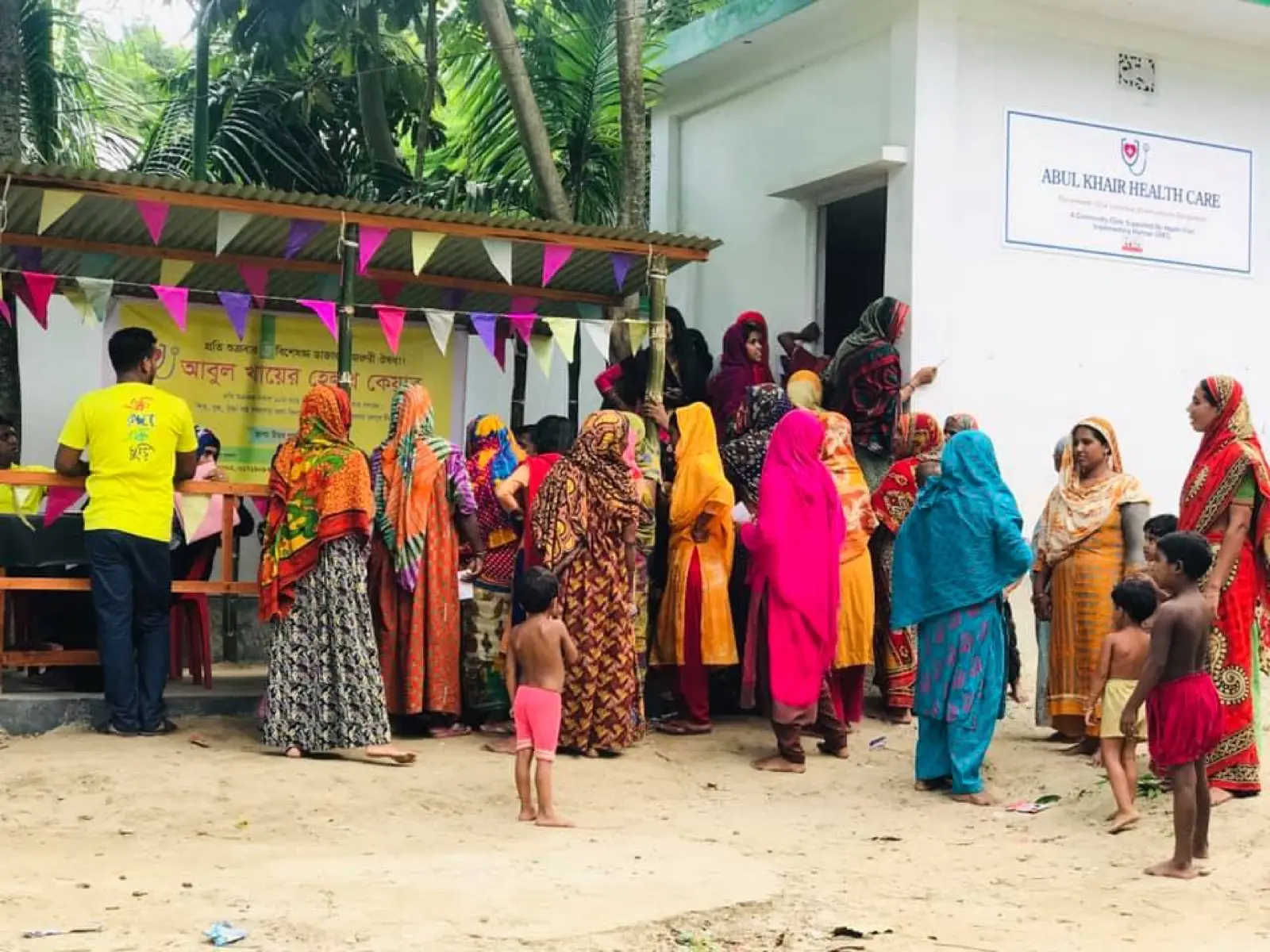 Villagers queue outside the Abul Khair Health Care office on a camp day in 2019