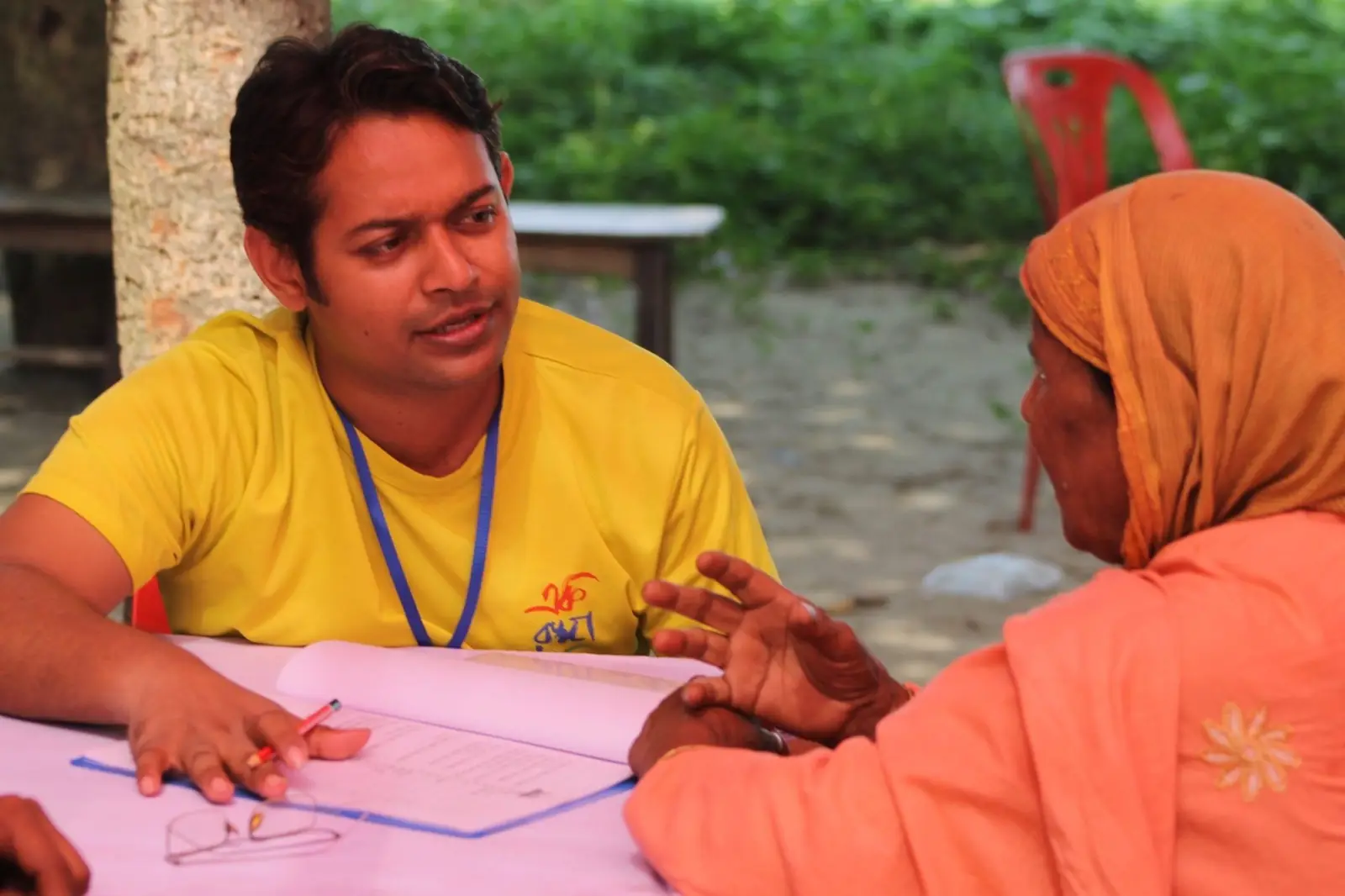 A volunteer writes out a prescription for a woman at a 2019 health camp