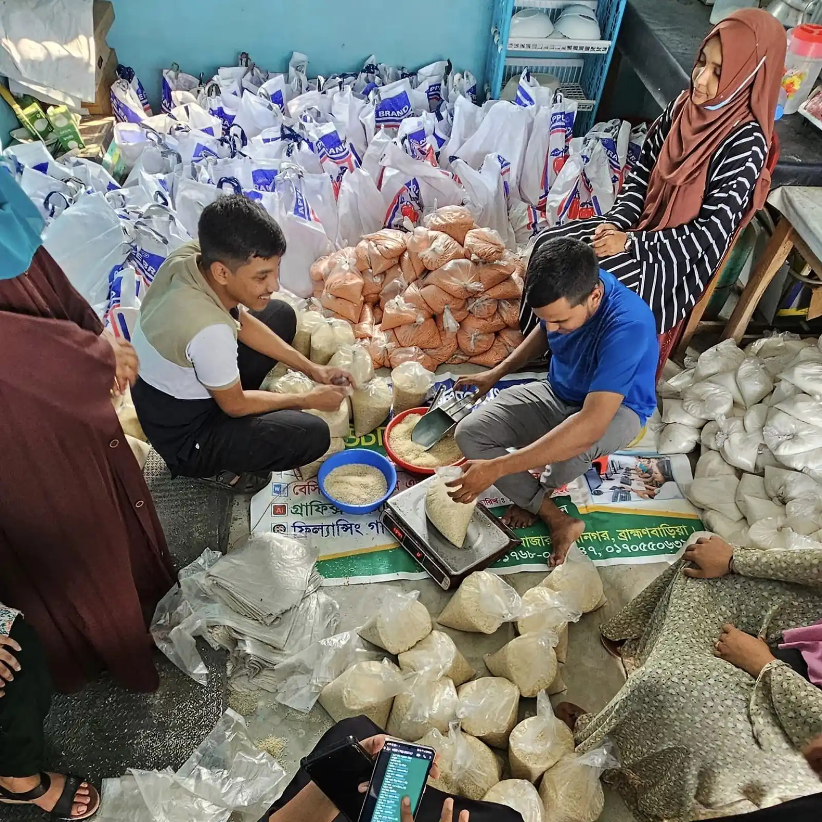 Volunteers pack food relief parcels into bags ready for distribution